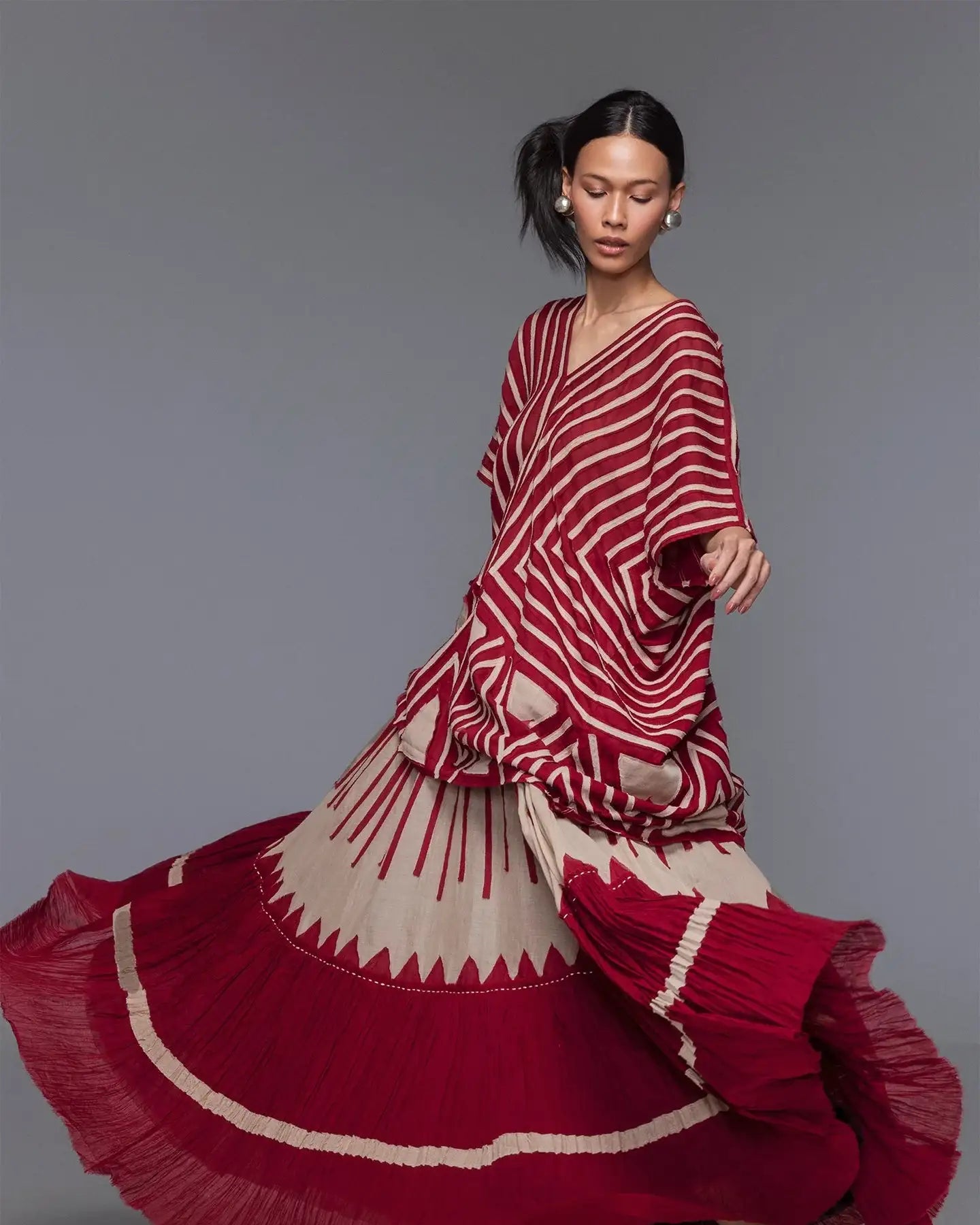 Woman in red and beige geometric print flowing dress, modern Singapore fashion