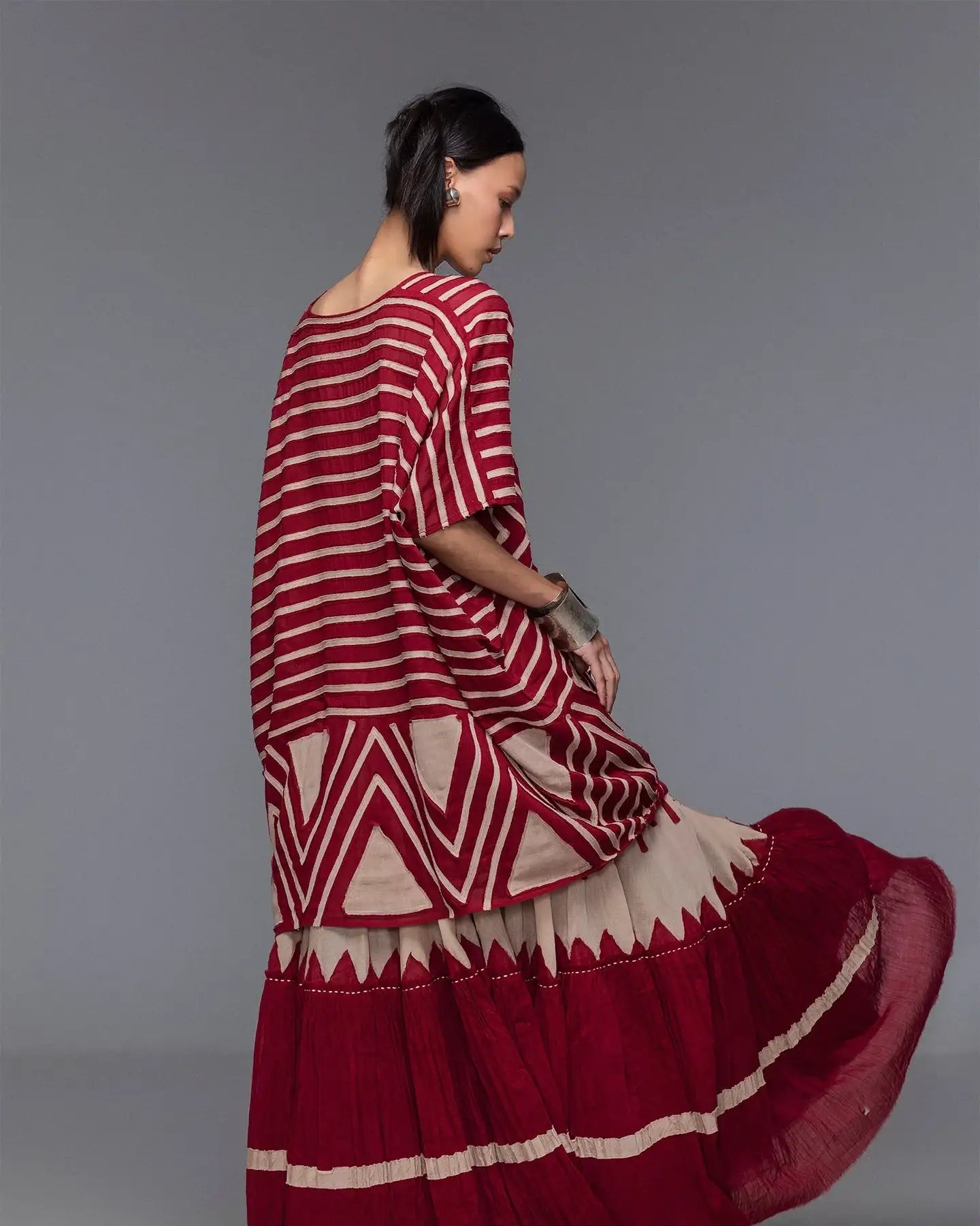 Woman in red and beige patterned maxi dress with geometric and striped design